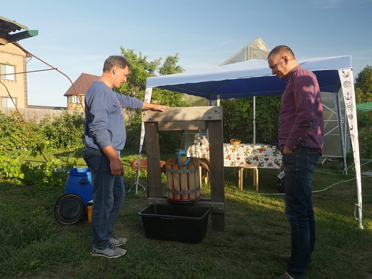 Сок для вина давится с помощью самодельного бочонка и пресса