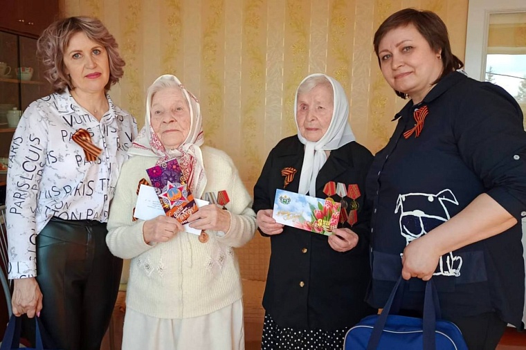 Поздравления Екатерине Дмитриевне Удоенко и Татьяне Дмитриевне Савицкой вручают депутат Ялуторовской городской думы Ольга Турнаева и волонтер Ялуторовского комплексного центра социального обслуживания населения Ольга Протасова.