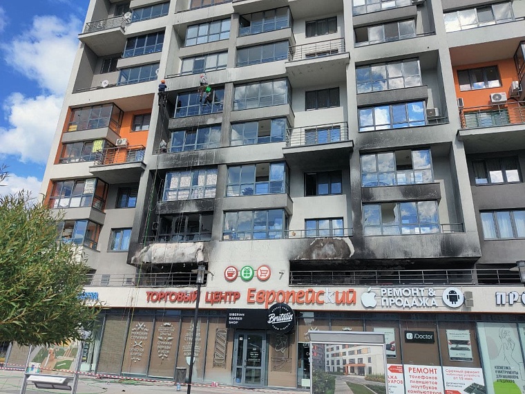 Работники отмывают фасад от копоти