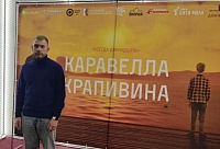 Режиссер Дмитрий Колобов на фоне плаката